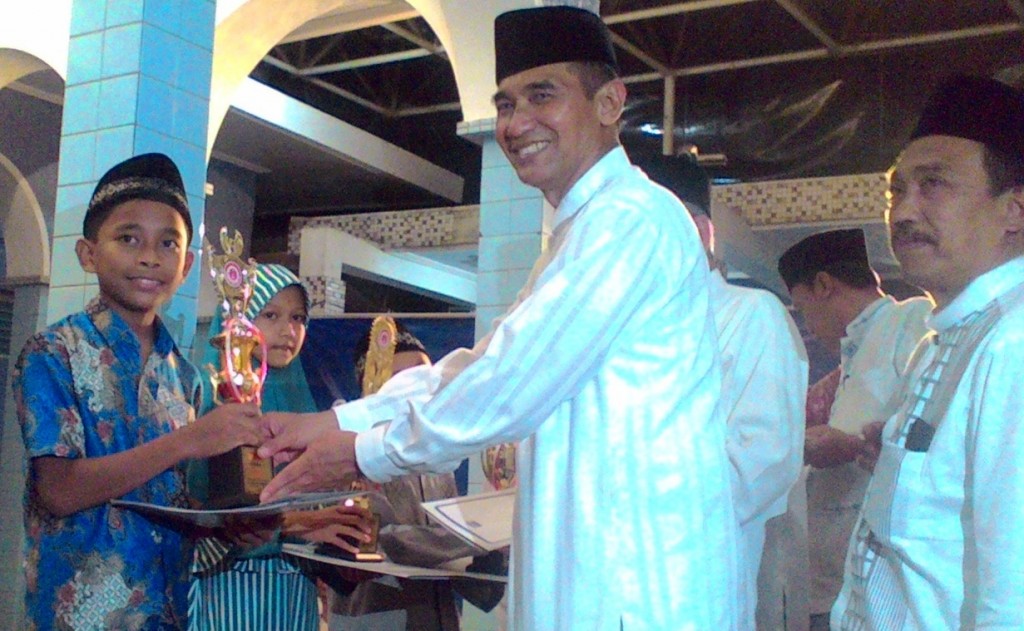 Sekretaris Daerah (Sekda) Kabupaten Kudus, Noor Yasin saat menyerahkan piala kepada para juara lomba MTQ tingkat pelajar dan umum Sukun for Education.